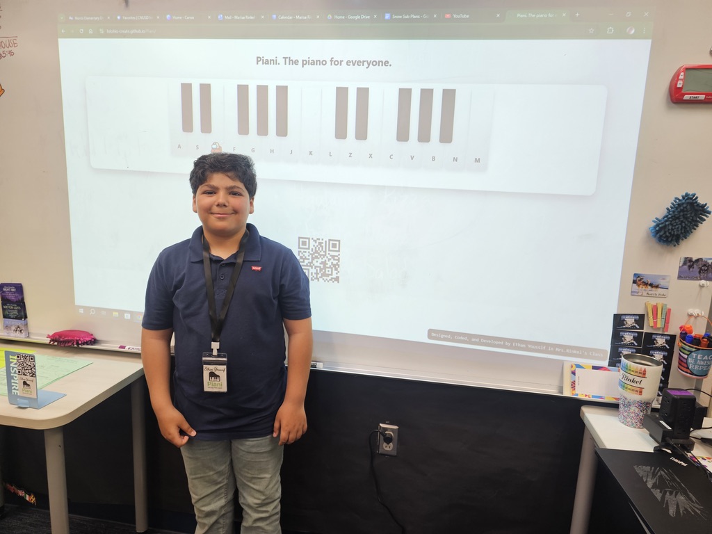 Ethan Youssif standing in front of a piano project display